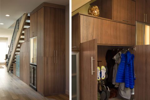 Almacenamiento en recibidor diseñado para caber debajo de las escaleras con armarios y ganchos personalizados con acabado en madera oscura de California Closets