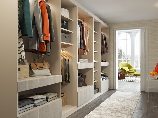 Walk in closet repurposed from a hallway with open shelving and floor cabinets by California Closets