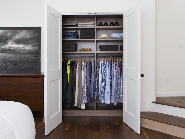 Custom reach in closet with hanging wardrobe and shelves for sweaters and shoes by California Closets