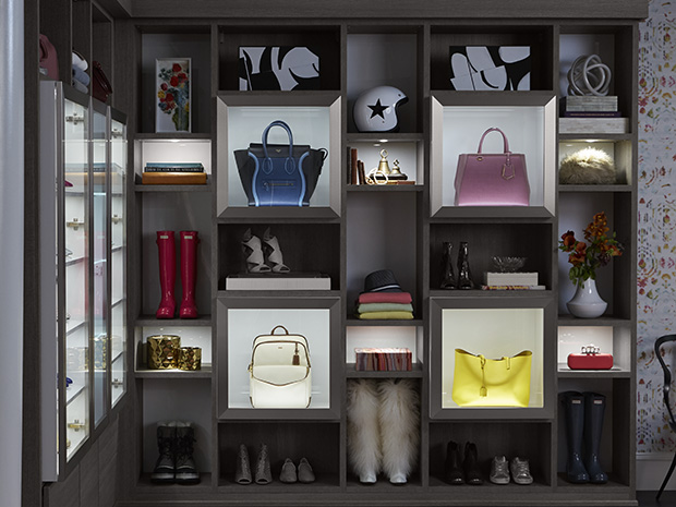 Bloggers shoe storage in a large walk in closet with lighting and glass door cabinets