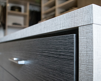 Close up shot of dark gray and brown cabinet with stainless steel hardware