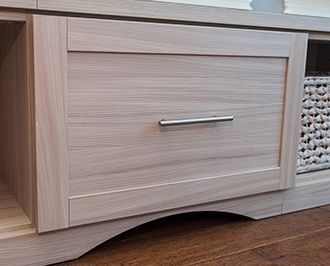 Light wood colored cabinet drawers with stainless hardware and naked finish