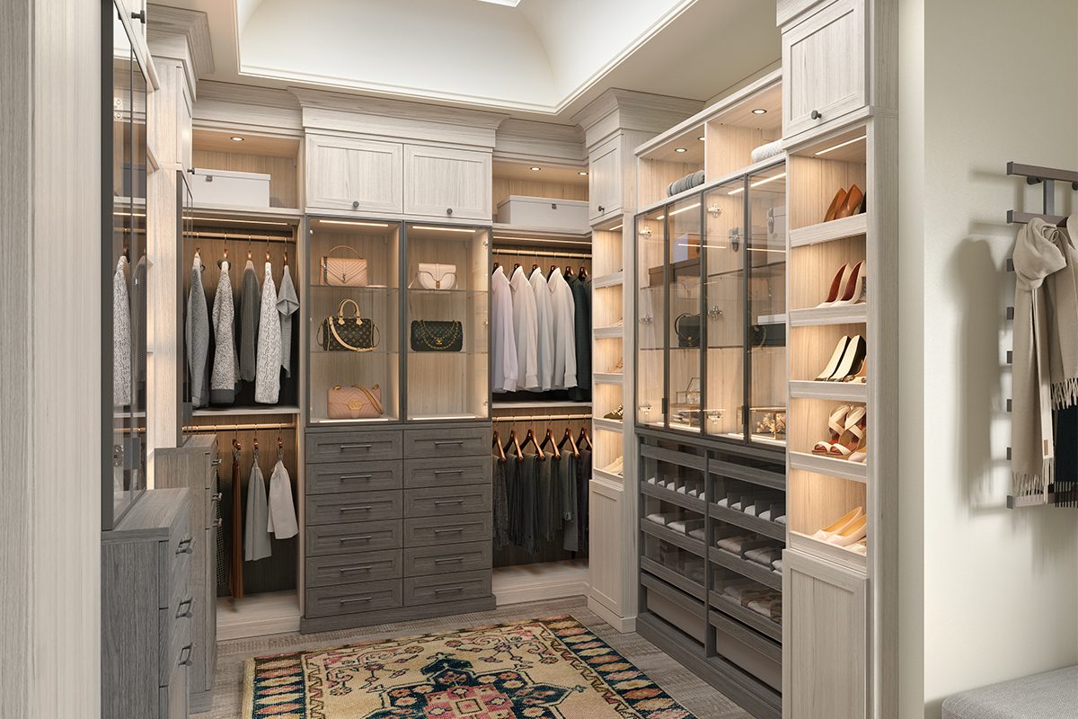 Walk in closet in light wood grain finish with shoe storage and custom LED lights by California Closets