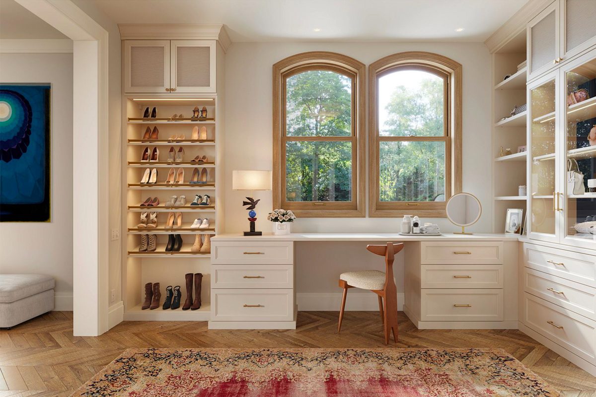 Cloffice designed with custom cabinets, open shelves for shoe storage and a desk in light wood finish by California Closets