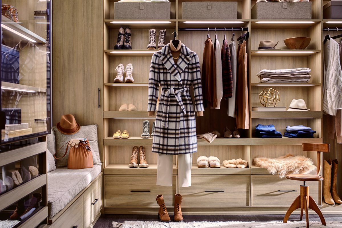 Custom closet with walk in desgin in a natural wood grain finish with floor to ceiling open shelves, drawers and shoe storage by California Closets