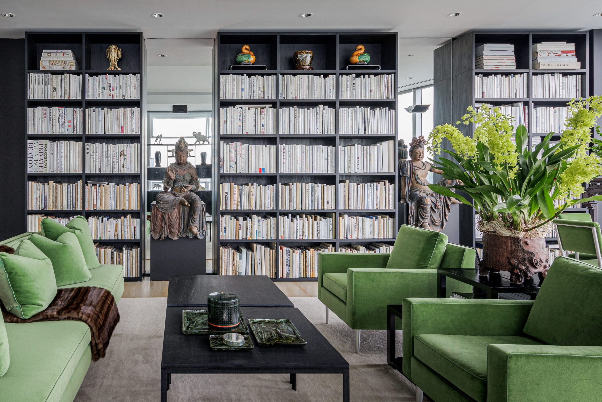 Sala de estar contemporánea con estanterías del suelo al techo en acabado de madera oscura por California Closets