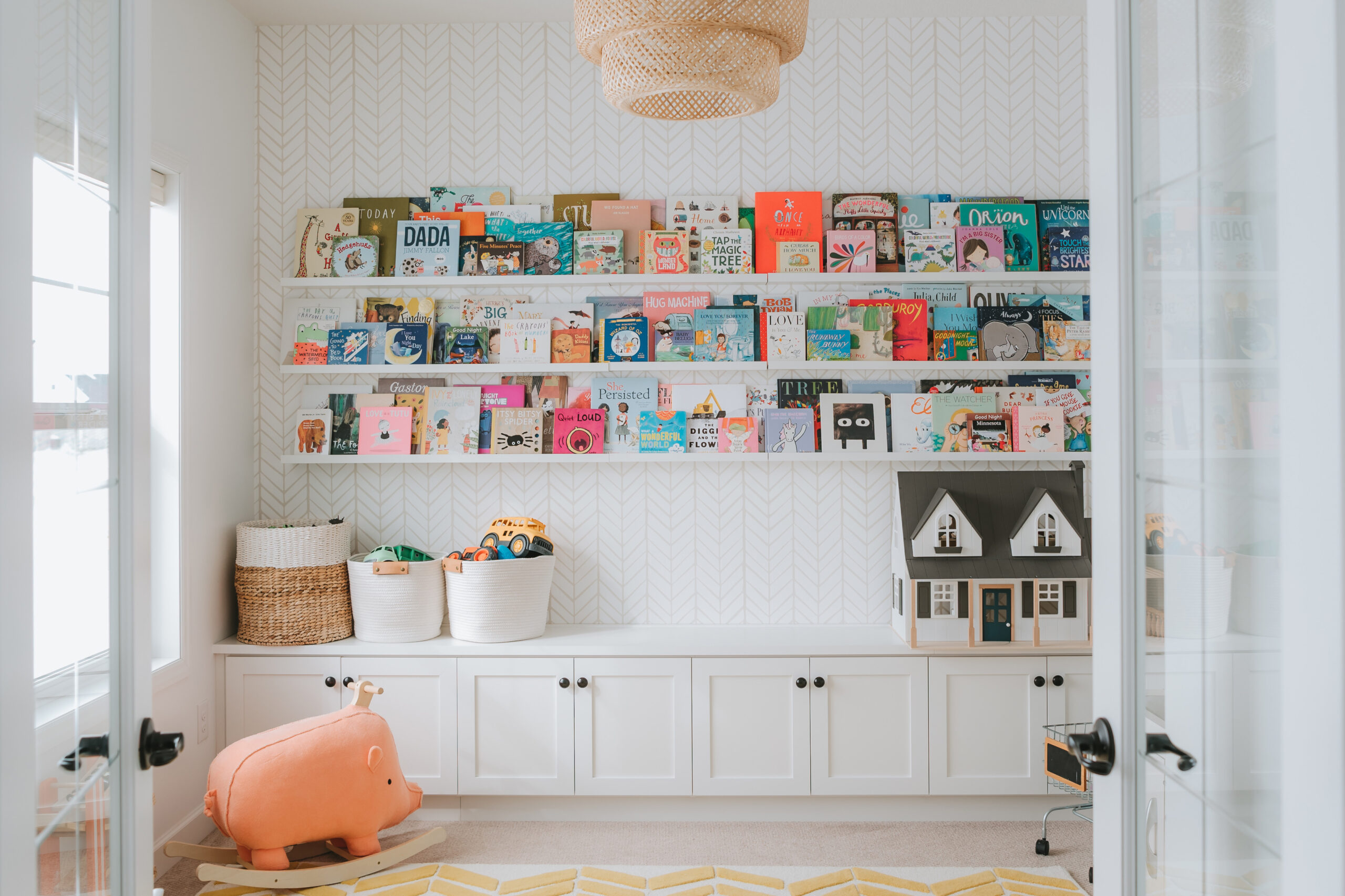 Children's home libarary shelves with custom cabinet storage in white wood grain finish by California Closets