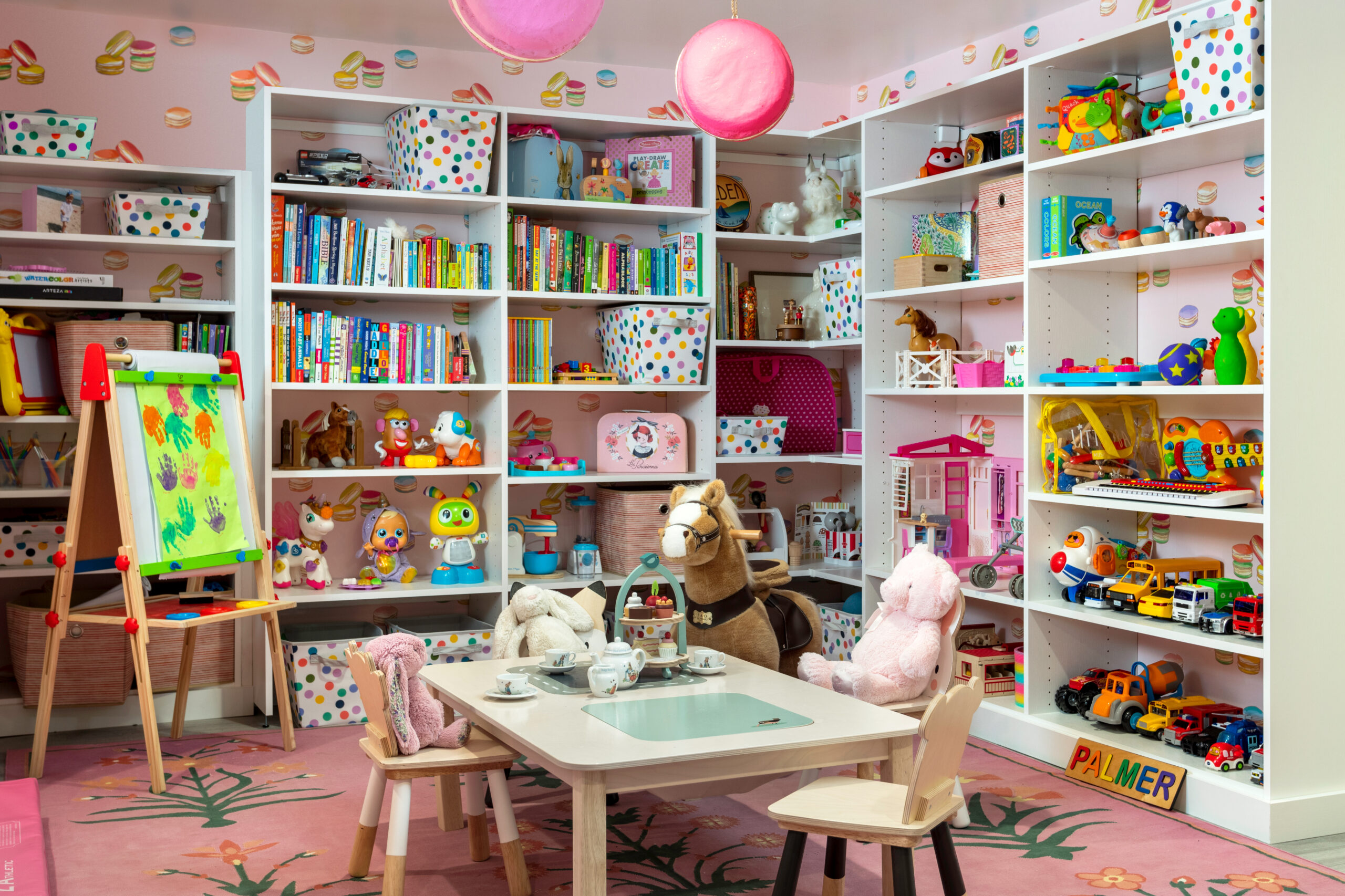 Playroom with custom bookshelves, tea party table, artist's studio and custom storage by California Closets