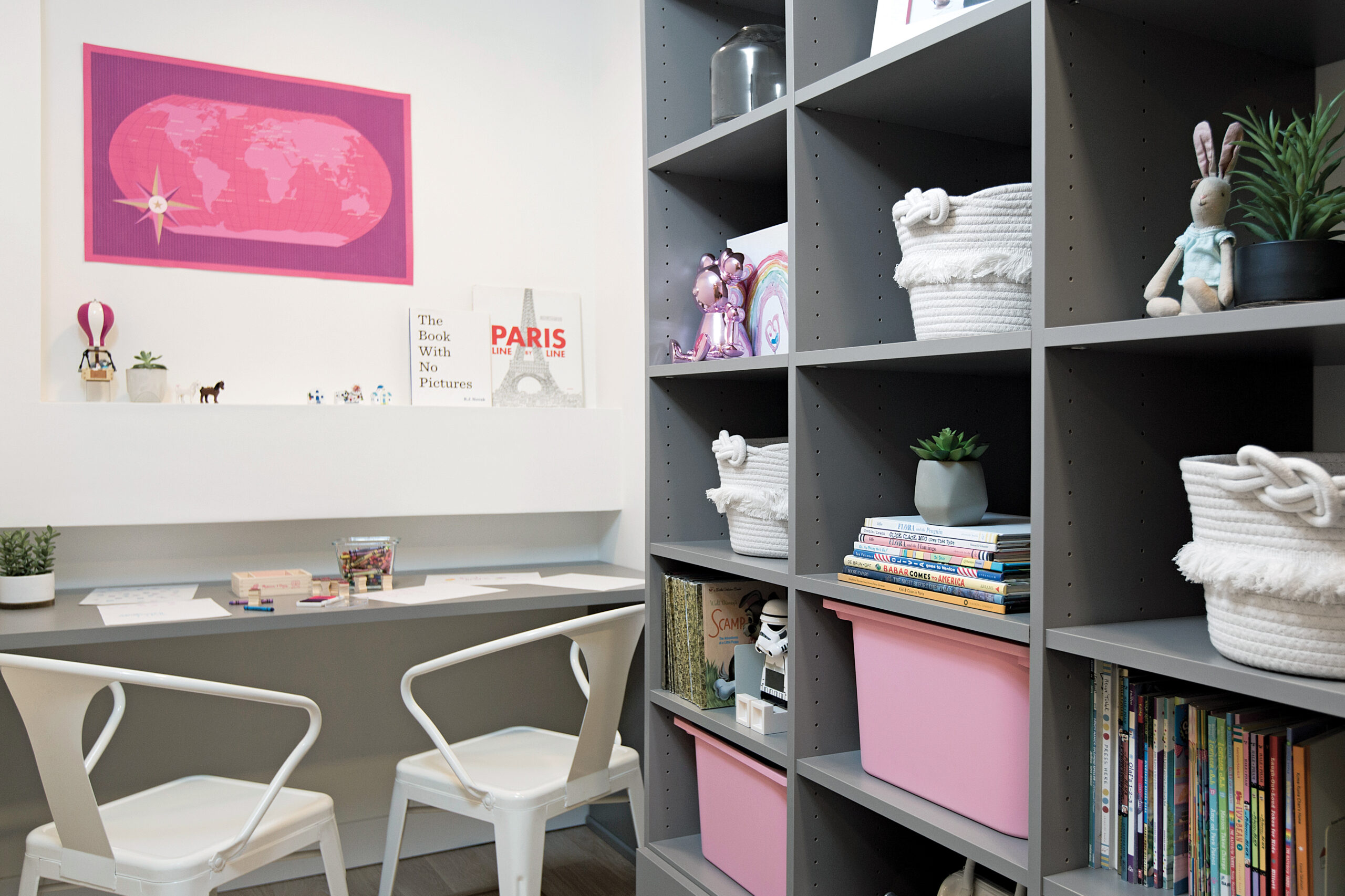 Teen's playroom grows up to become a study area with library shelving, custom cabinets and drawers in white wood grain finish by California Closets